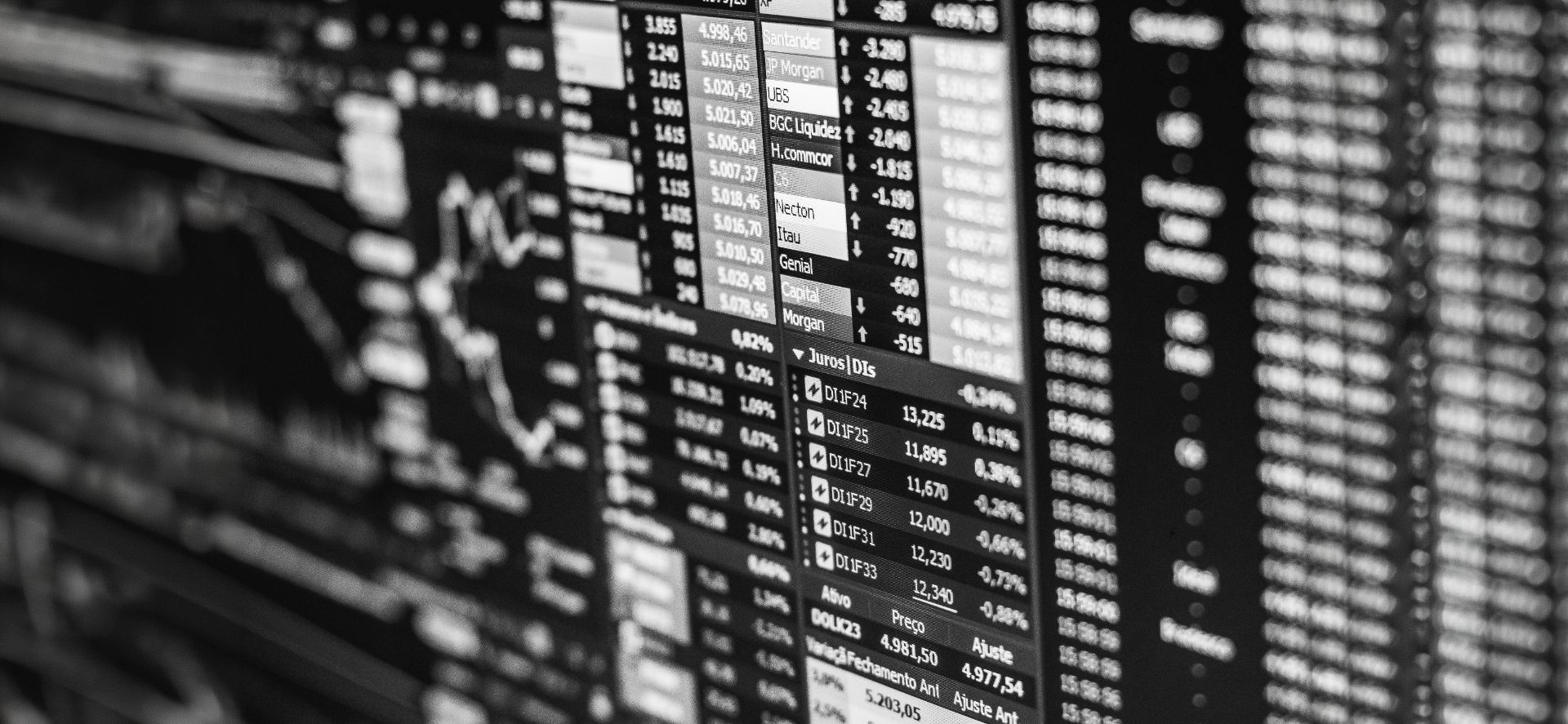 Close-up of a financial market trading screen showing real-time price data, bid/ask spreads, and instrument tickers in black and white.